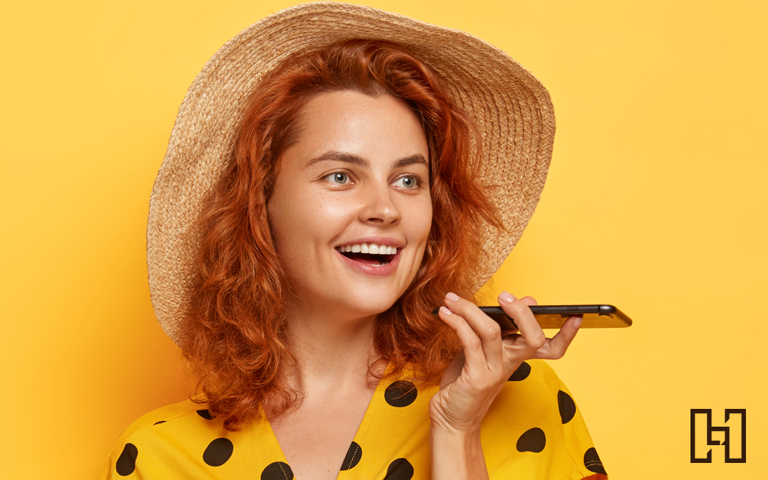 woman on yellow background using her phone for voice search photo for Hurrdat blog