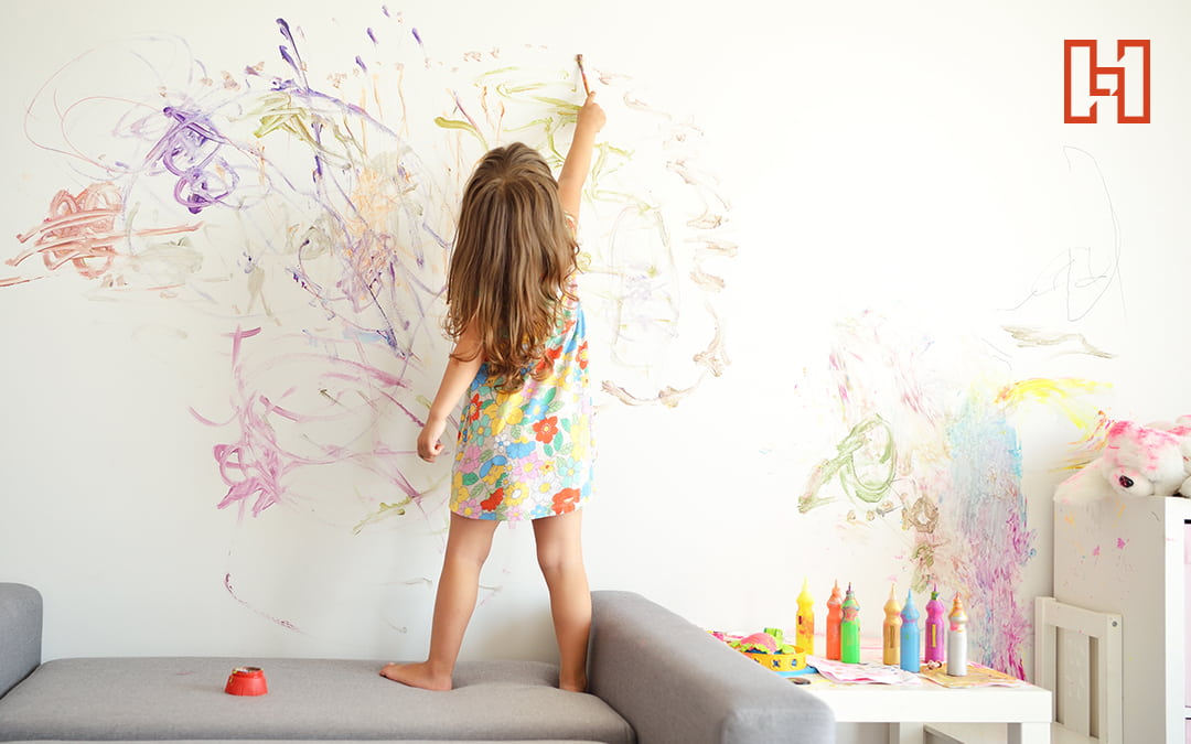Girl Coloring All Over a Wall with Crayon