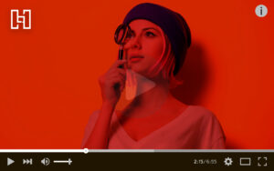 Woman holding a magnifying glass up with a YouTube video player surrounding her