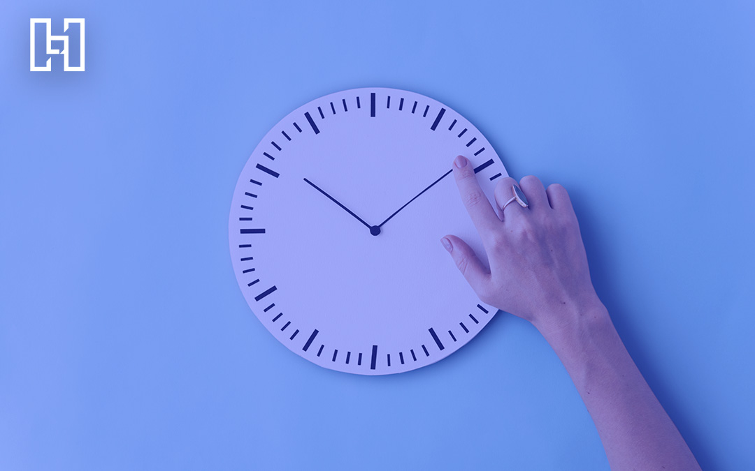 Analogue clock with person hand adjusting the minute hand