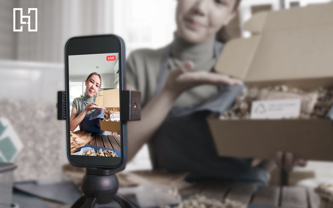 Woman holding up box while recording on camera for YouTube Shorts