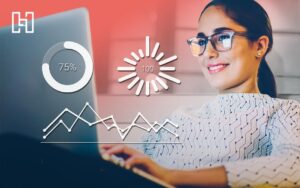 Woman smiling and typing on laptop with performance graphics in front of her