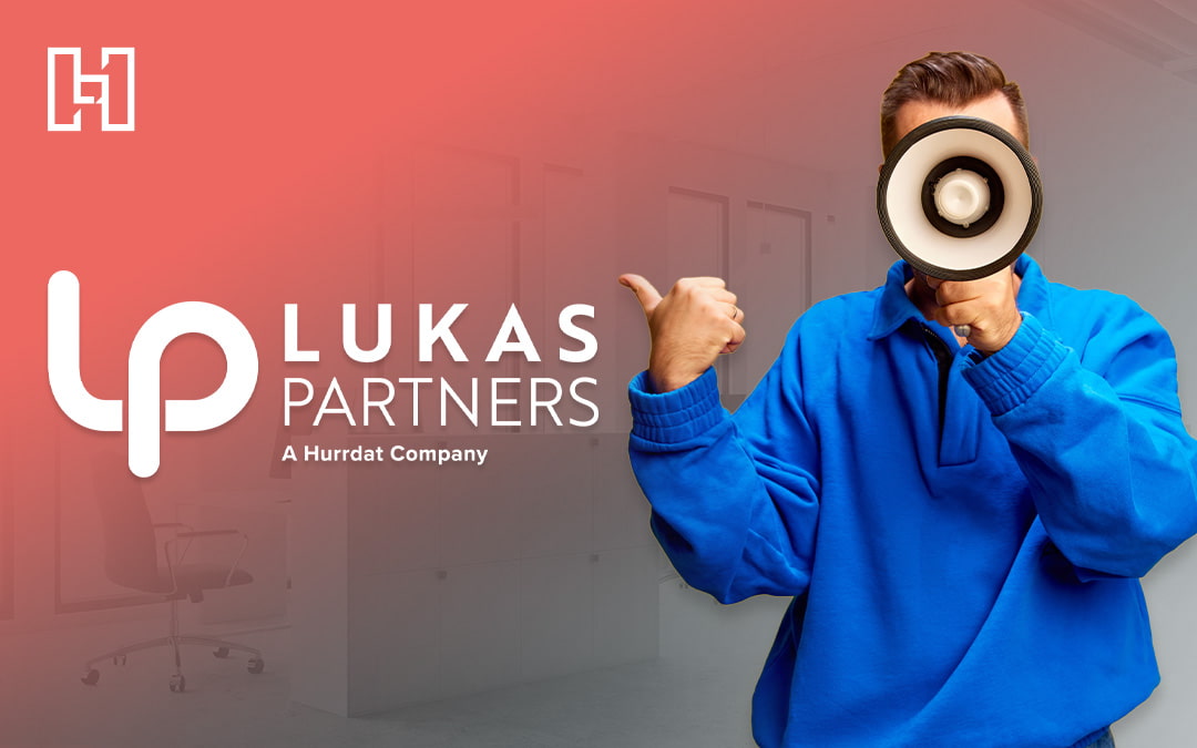 Person in a blue sweatshirt speaking through a megaphone and gesturing towards superimposed Lukas Partners logo