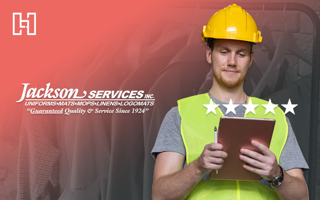 A worker in a yellow hard hat and safety vest reviews a tablet, alongside the Jackson Services Inc. logo and five-star rating graphic.