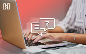 Person typing on a laptop with chat and question mark icons overlaid, representing FAQ and SEO content strategy